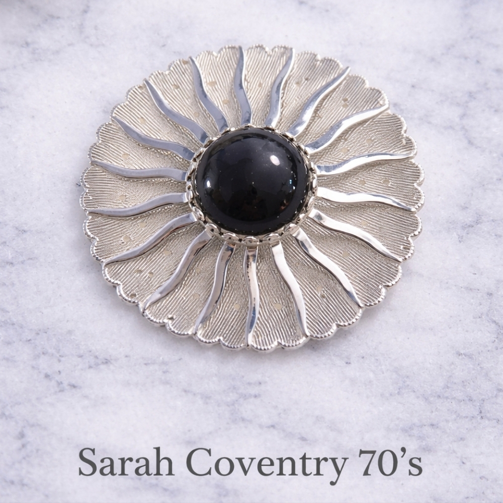 SARAH COVENTRY Silver-Tone Sunburst Brooch with Black Cabochon Center.